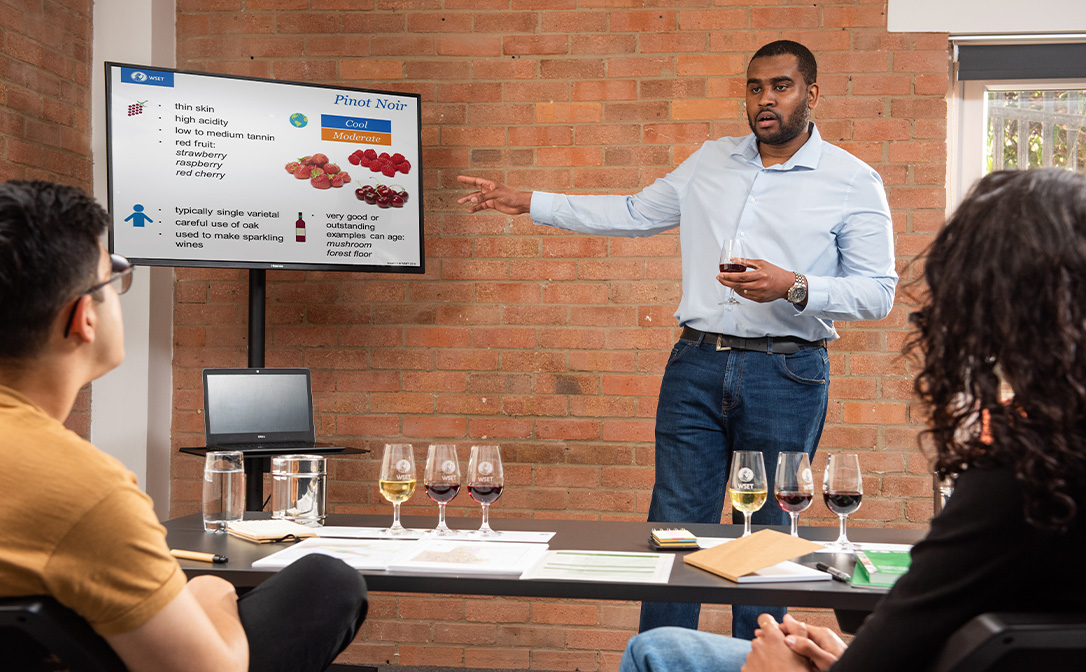 WSET classroom with teacher describing a wine as part of the wine course
