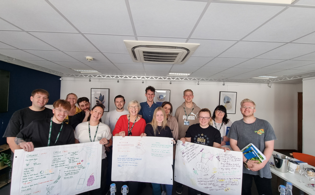 A group of students showing their group work on large posters