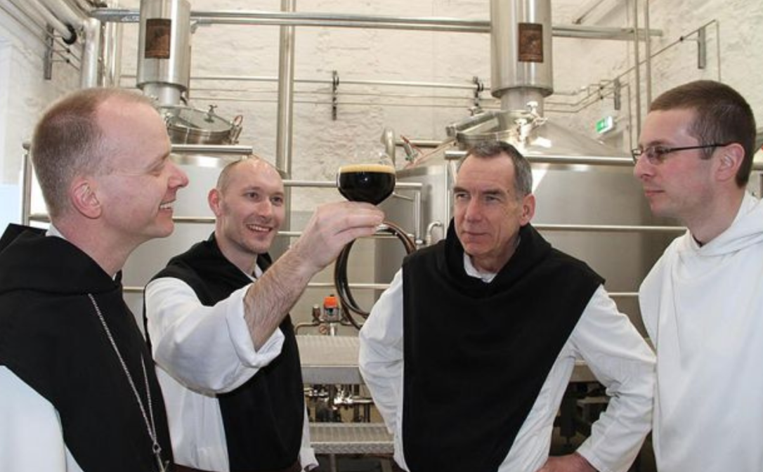 Four people inspecting the beer they have produced