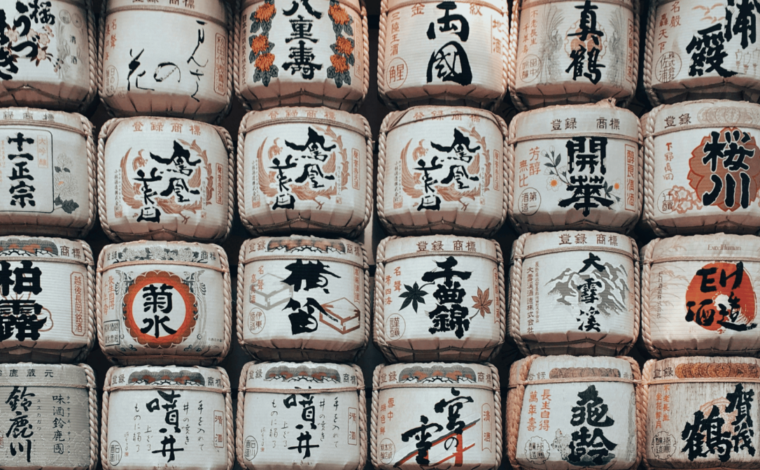 Cream-coloured sake barrels with designs in black and red